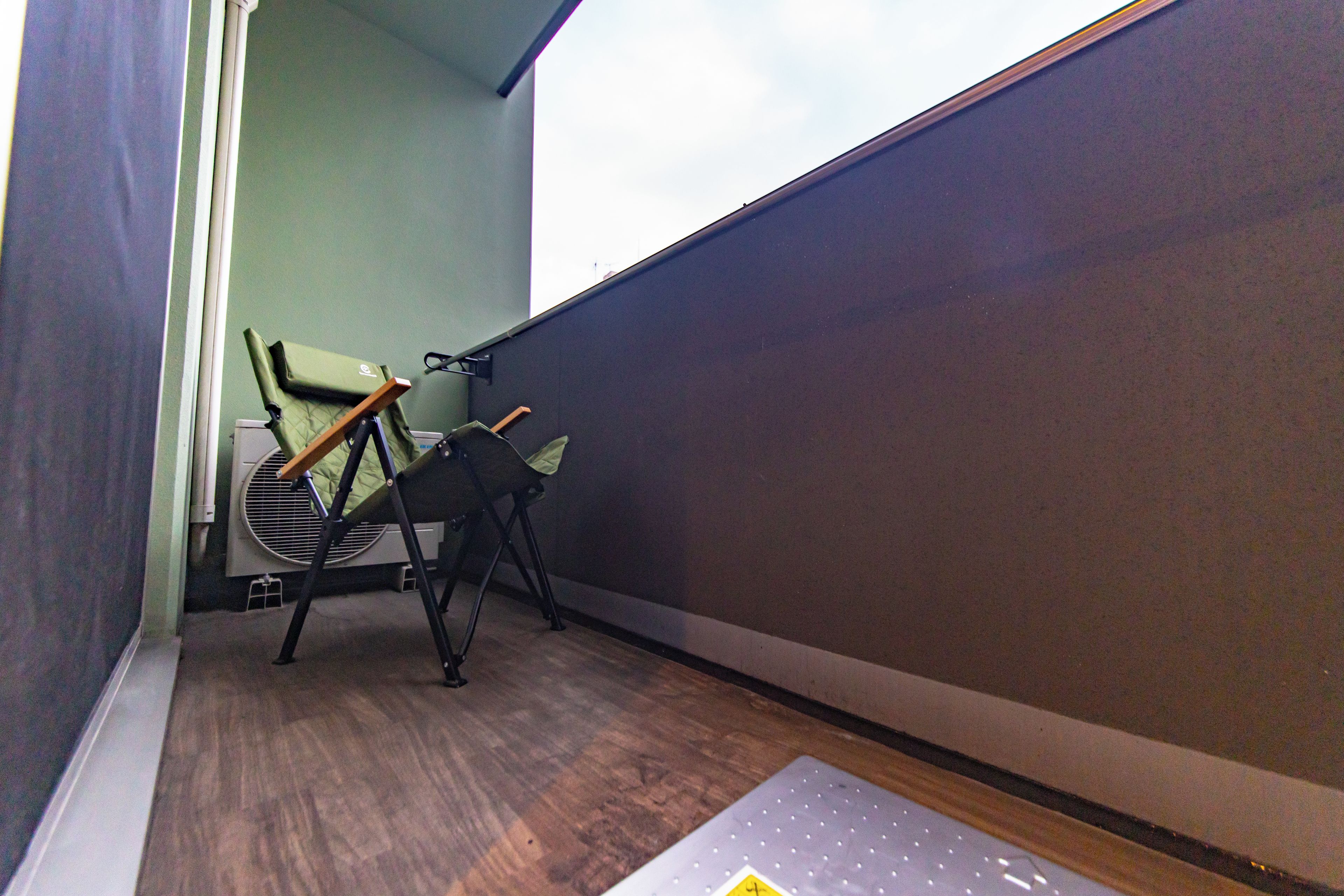 A corner of a room with a chair, a radiator, and a window.