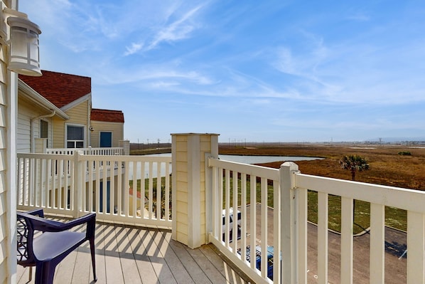 Een balkon met uitzicht op een strand en een uiterwaardenlandschap.