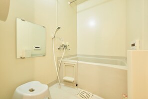 Une salle de bain comprenant des toilettes, un lavabo, un miroir et une baignoire.