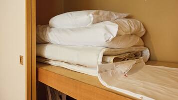 A neatly made bed with white linens in a room with wooden furniture.