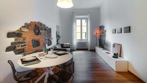 Ein Essbereich mit Backsteinwand, weißem Tisch und Stühlen.