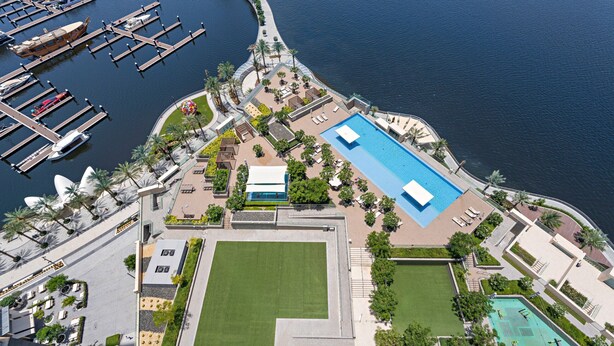 Vue aérienne d’une marina avec des quais, une piscine et des espaces aménagés.