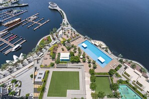 Vue aérienne d’une marina avec des quais, une piscine et des espaces aménagés.