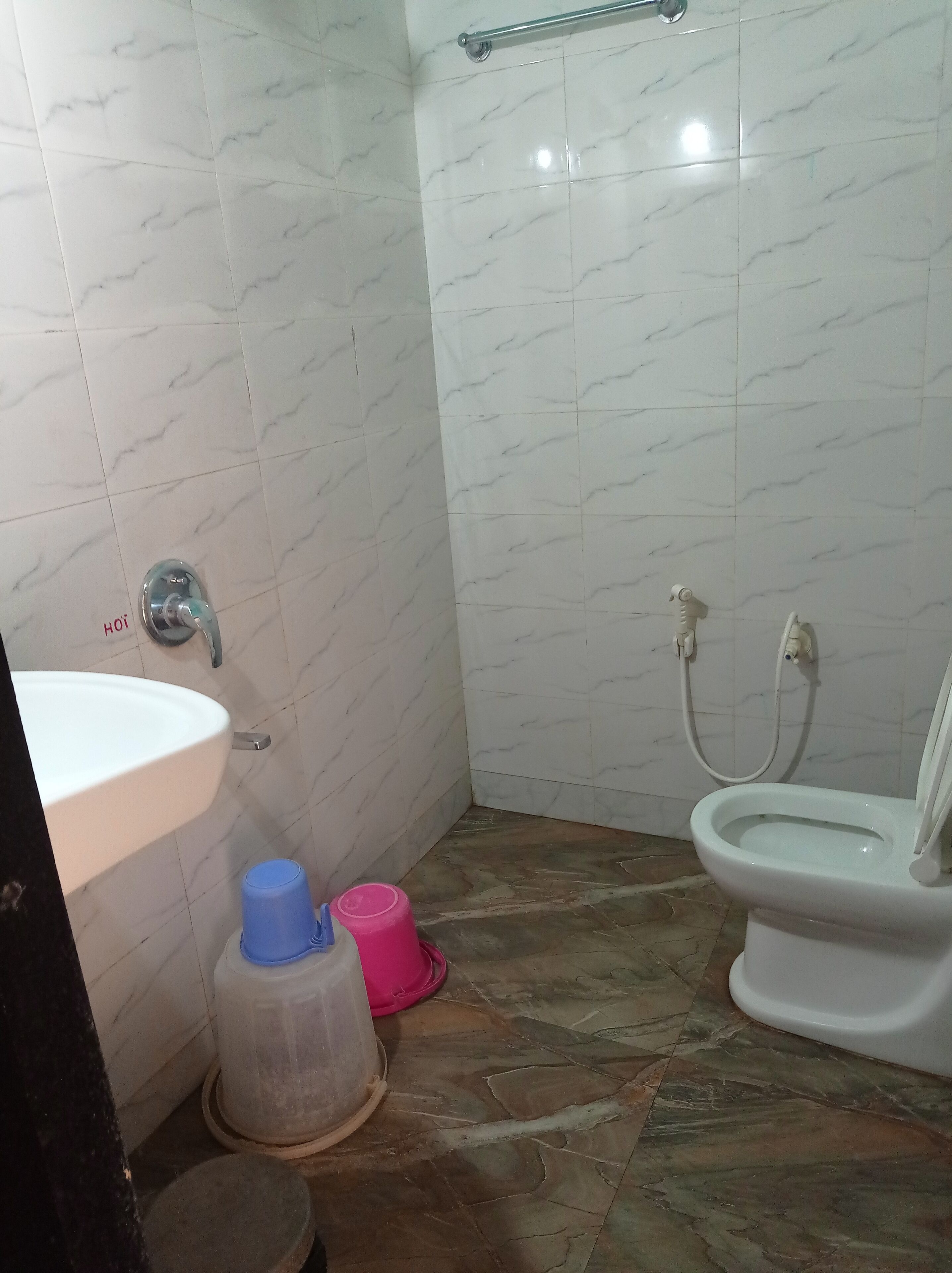 Un baño con lavamanos, inodoro y zona de ducha.