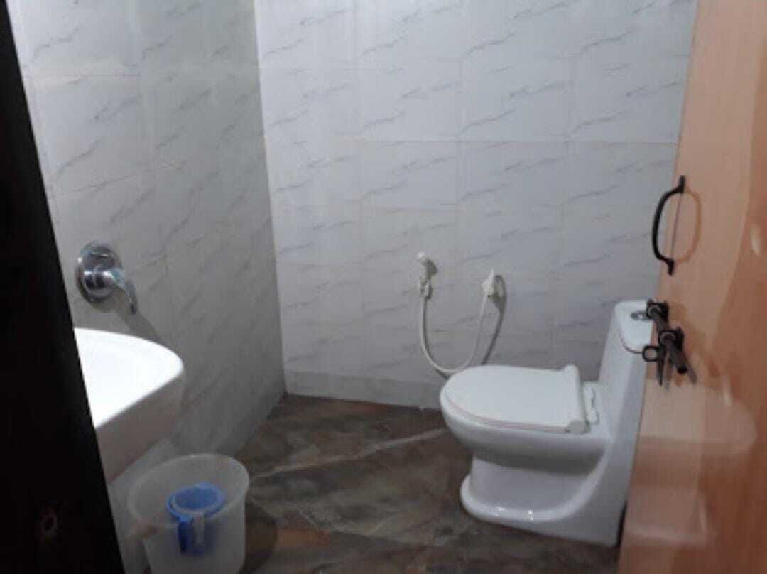 A small bathroom with a toilet, sink, and shower.