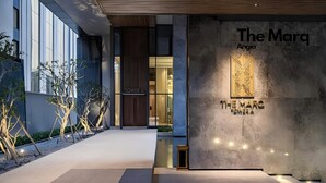 A modern building facade with a large sign reading "The Marq Angia". - The MARQ  By An Gia Hospitality (Ho Chi Minh City)