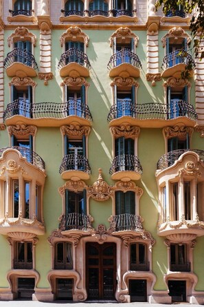 Um edifício com varandas elaboradas, janelas grandes e molduras decorativas.