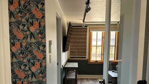 Ein Flur mit strukturiertem Wandpapier, einer Treppe und Blick in einen Essbereich.