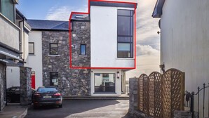 A modern building with a stone facade, a flat roof, and a large window. - Carraroe Apartment ideal base to tour Connemara (Carraroe)