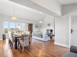 A spacious living area with a dining table, chairs, and a sofa. - Paddy Carroll´s, Ballyconneely (Ballyconneely)