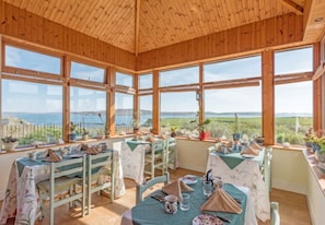 Enjoy meals with expansive views of the surrounding landscape from this dining area with high ceilings and large windows.