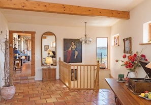 Stunning interior space with a high ceiling, wooden staircase, and chandelier.
