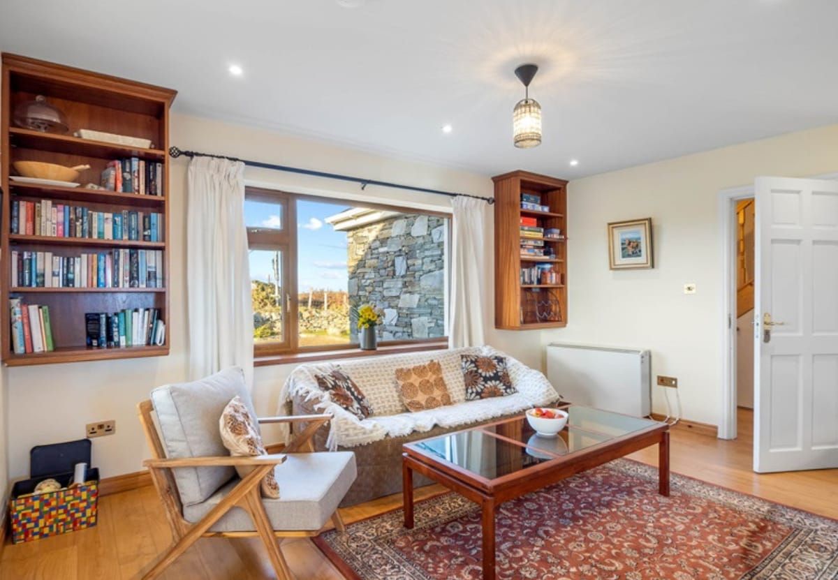 Ein gemütliches Wohnzimmer mit einer Couch, einem Couchtisch und Bücherregalen.