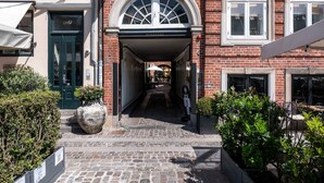 A narrow alleyway leading to a building with a green door labeled "Jr61" and a sign "NYHAVNGS" above the entrance. - Nyhavn63 Suites 2 by Daniel&Jacob's (København)