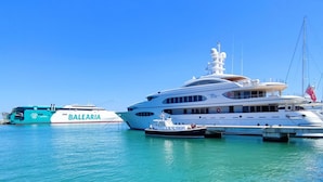 A large yacht docked at a marina with a smaller boat nearby. - Ático Marina Real III (Dénia)