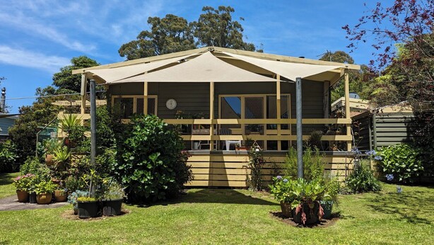 A two-story house with a covered porch, surrounded by a well-maintained garden with various potted plants and a lawn. - Al'May Rawson escape, family cottage.
Entire Home in Rawson, Australia  (Rawson)