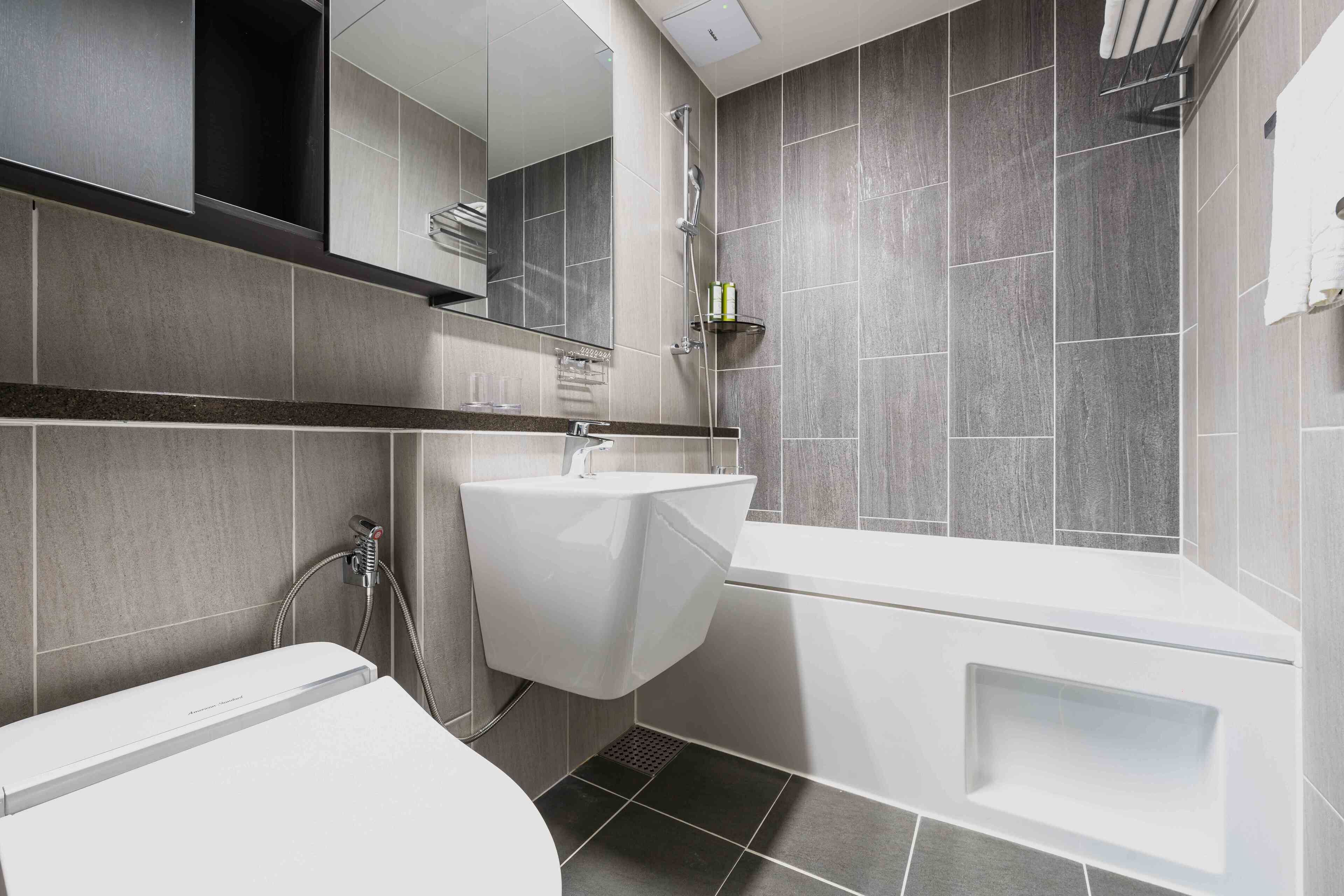 Une salle de bain moderne équipée de toilettes, d’un lavabo et d’une baignoire.