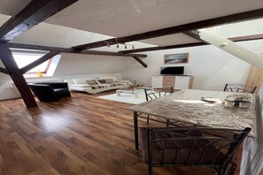 Relax in this stylish loft with a sofa, dining table, and mounted TV.