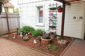 Stroll through the serene garden, surrounded by a variety of potted plants and decorative items.