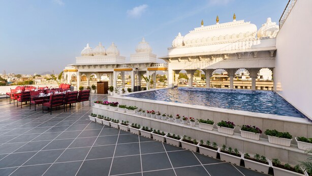 Une terrasse sur le toit dotée d’une piscine, d’un espace repas et présentant une architecture traditionnelle.