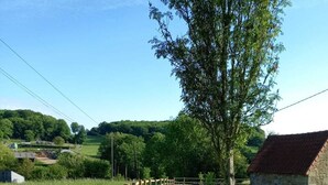 A rural road with a wooden fence and a grassy area.