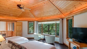 Een ruime kamer met een groot bed, een bureau en een televisie.