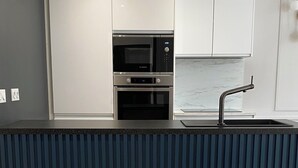Una cocina moderna con microondas, horno y lavaplatos integrados.