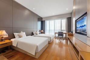 A hotel room with two beds, a desk, a chair, a TV, and a large window with curtains. - Side Apartment (Guangzhou)
