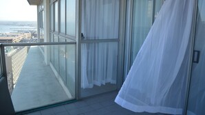 Ein Balkon mit Blick auf eine Stadtlandschaft und Wasser.