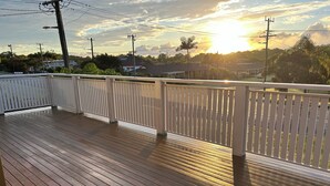 A wooden deck with white railings, overlooking a residential area with houses and trees. - The Rocks Family entertainer, just 10-min walk to town & beach! (South West Rocks)