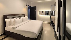 Une chambre d’hôtel moderne, dotée d’un grand lit, d’un bureau et d’un miroir.