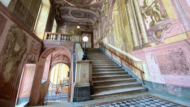 A grand staircase with ornate wall decorations and a checkered floor. - Mini Apartment With Bathroom and Kitchen (Portici)