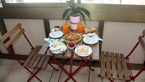 A breakfast table with plates, cups, and a potted plant. - Mini Apartment With Bathroom and Kitchen (Portici)