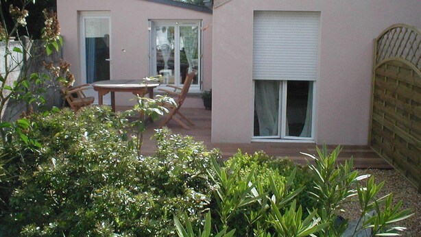 Un edificio rosa con un patio, una mesa y sillas.