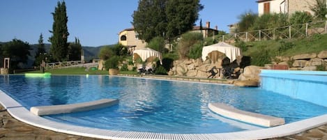 Una piscina al aire libre de temporada, sombrillas