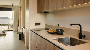 Una cocina moderna con armarios de madera, un lavamanos de acero inoxidable y vistas al mar.