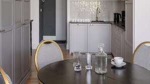 Un comedor con una mesa redonda, sillas y una cocina al fondo.