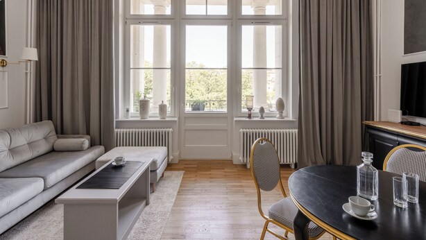 Una sala moderna con sofá, mesa de centro y mesa de comedor.