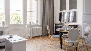 Un comedor moderno con una mesa redonda, dos sillas y una mesita auxiliar blanca.
