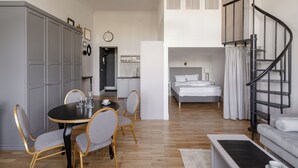 Un interior moderno con comedor, dormitorio y escalera.
