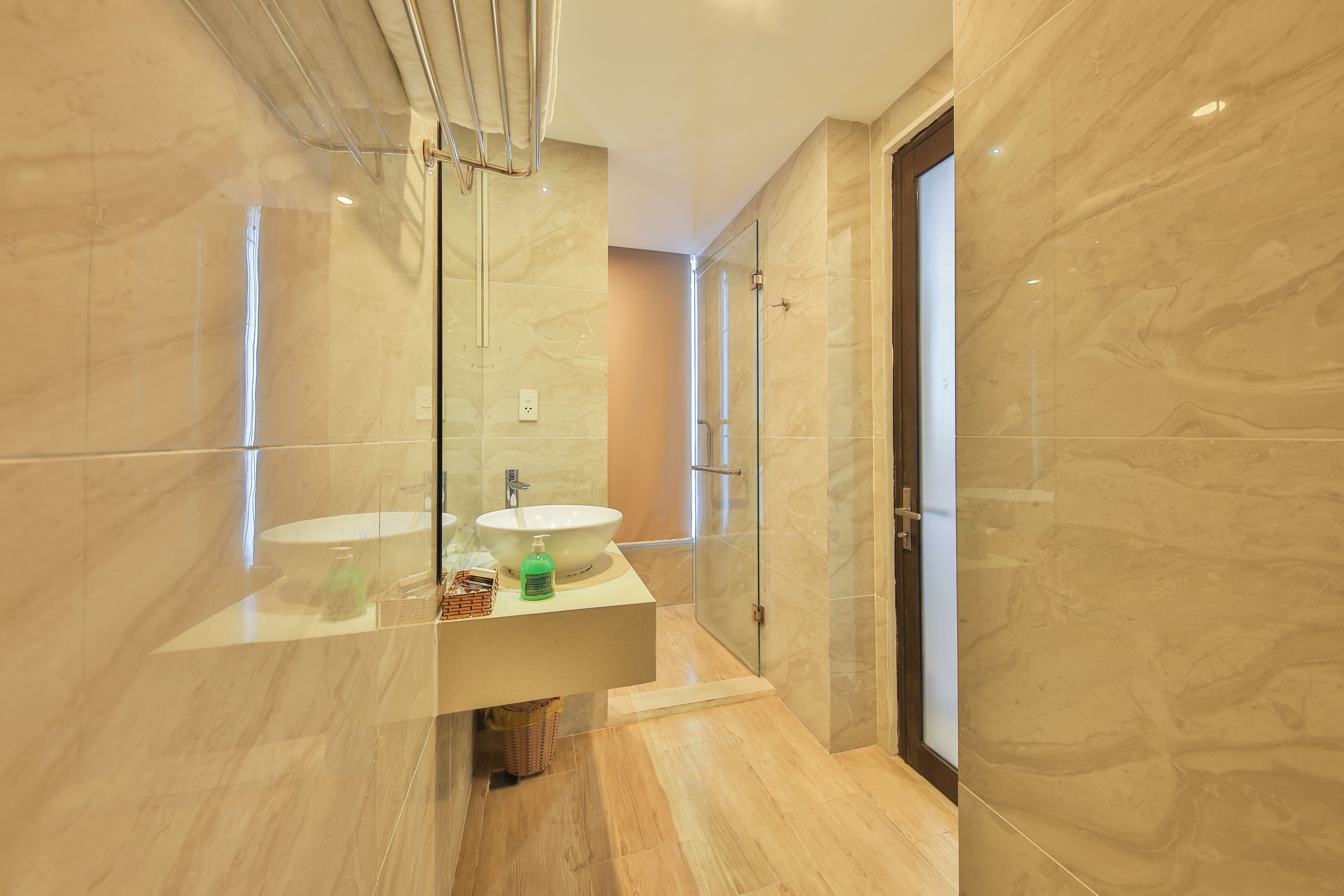 A modern bathroom with a large mirror, a sink, and a glass shower enclosure.