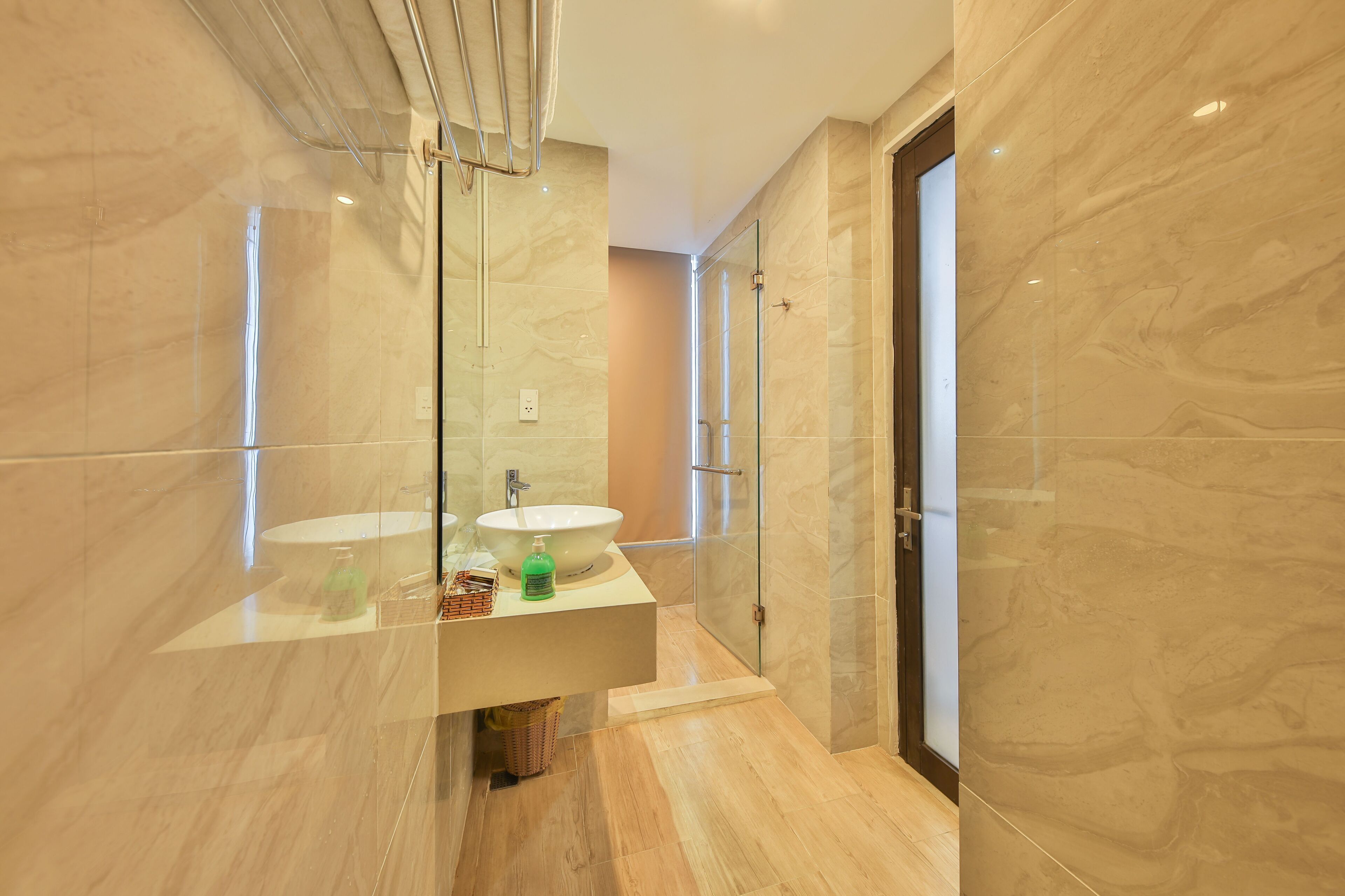 Un baño moderno con cabina de ducha de vidrio, un lavabo con encimera de mármol y un espejo grande.