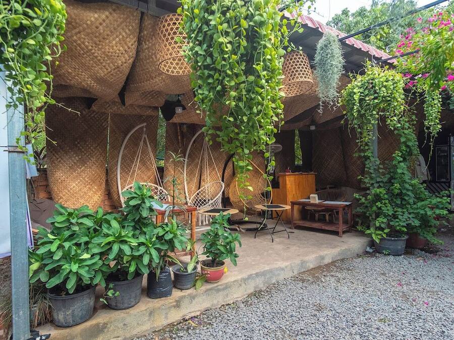 A rustic outdoor seating area with wicker furniture and potted plants.
