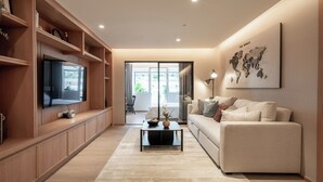 Ein modernes Wohnzimmer mit Flachbildfernseher, einer Couch, einem Couchtisch und einer Weltkarte an der Wand.