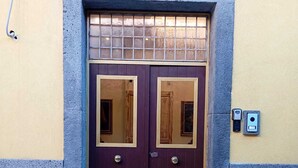 Una puerta doble con marco de piedra y un pequeño ventanal encima.