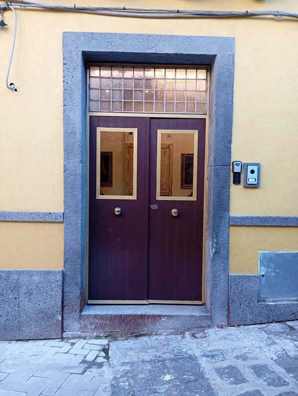 A double door with a stone frame and a small window above it.