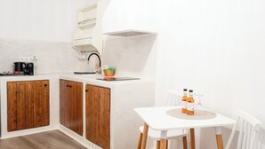 Une cuisine moderne avec des meubles en bois, un plan de travail blanc et une petite table à manger avec des chaises.