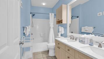 A bathroom with a bathtub, toilet, and sink.