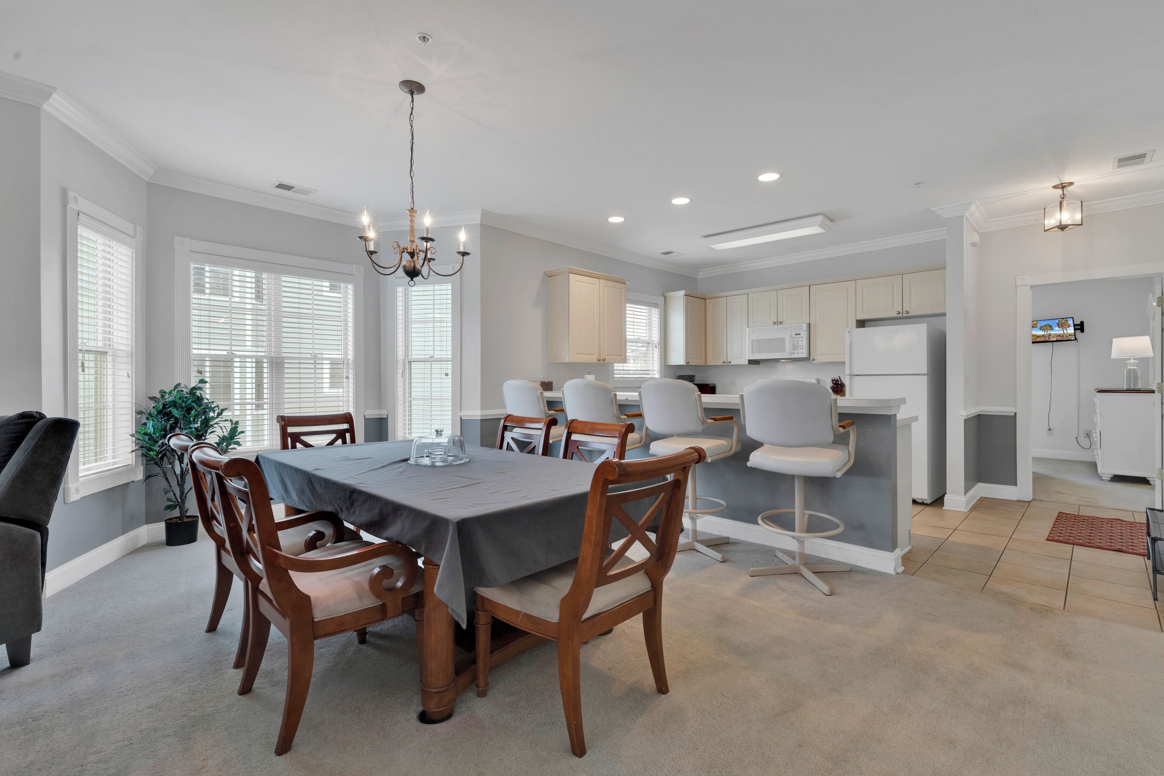 A modern kitchen with white cabinets, a microwave, and a refrigerator.