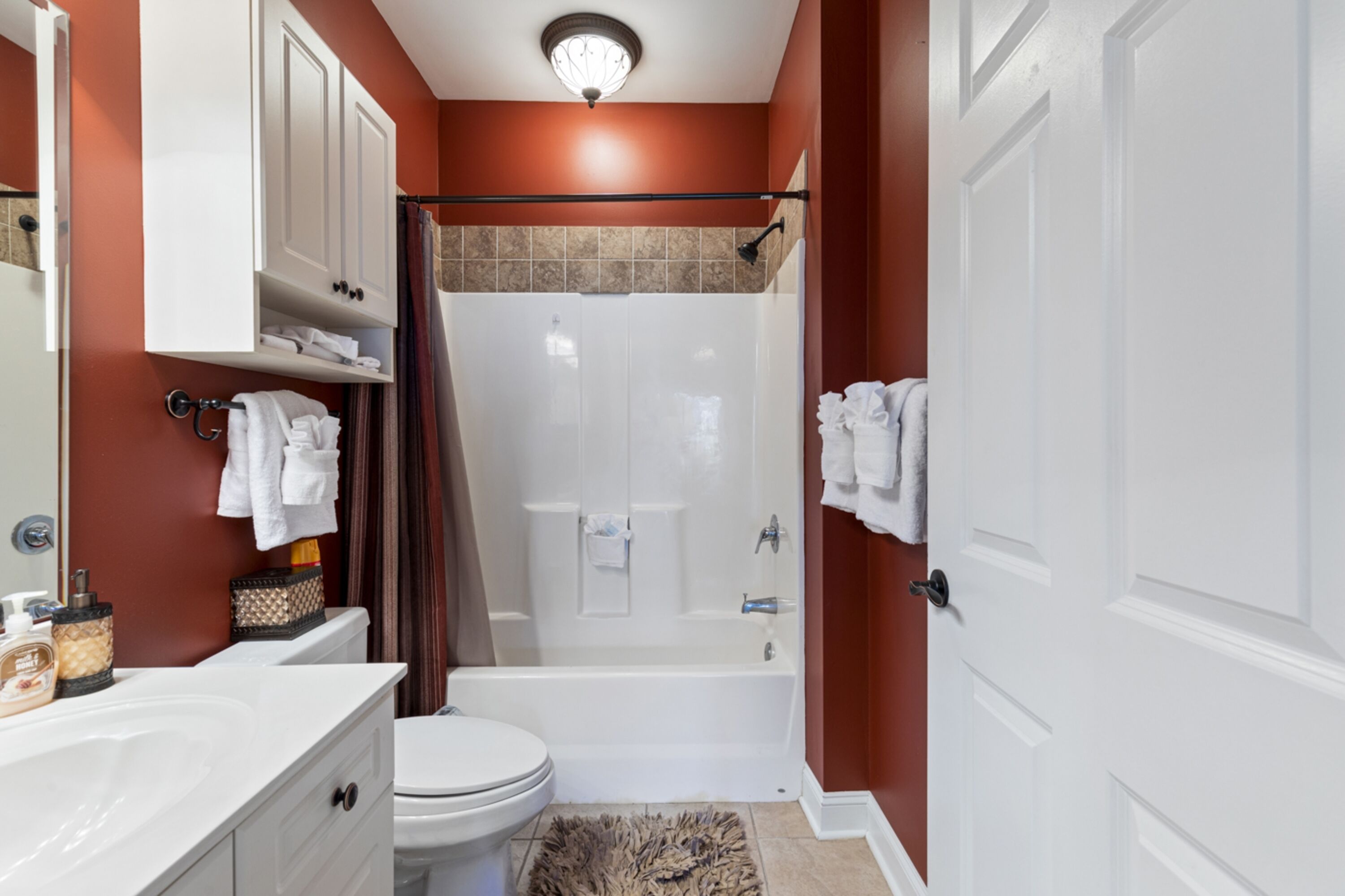 A bathroom with a shower, toilet, and sink.